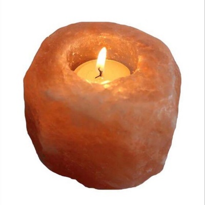 Castiçal de sal rosa do Himalaia com vela acesa