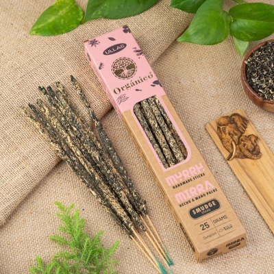 Incensos em pau Myrrh Mirra feitos à mão numa caixa rosa e castanha sobre tecido de juta com planta verde e incensário de madeira com elefantes.