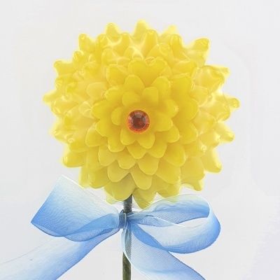 Vela amarela em forma de flor com laço azul