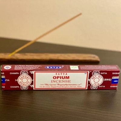 Caixa de incenso Satya Opium em vermelho com texto branco e azul em superfície escura