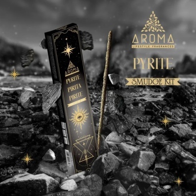 Embalagem preta de kit de incenso Aroma Pyrite Smudge Kit com detalhes dourados sobre pedras cinzentas e pretas