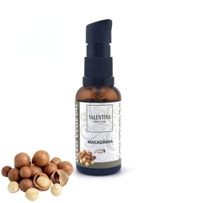 Frasco de óleo de macadâmia Valentina Body Care com nozes de macadâmia ao lado