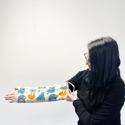 Mulher segurando almofada cilíndrica com padrão colorido de animais