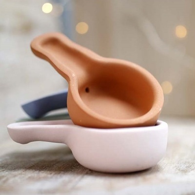 Três tigelas com pega em cerâmica nas cores branca, terracota e azul escuro, empilhadas.