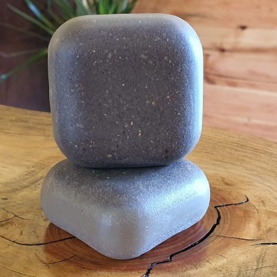 Dois blocos quadrados cinza empilhados sobre mesa de madeira