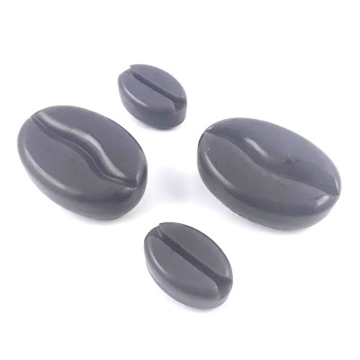 Peças em tecido cinzento em forma de grão de café sobre fundo branco