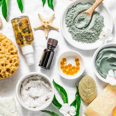 Produtos de cuidados pessoais naturais com esponja, cremes e cápsulas sobre fundo branco