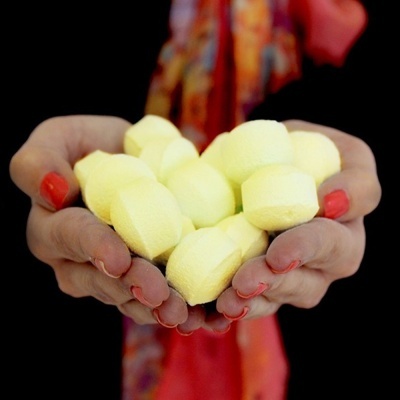 Mãos segurando muitas esponjas faciais amarelas