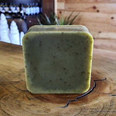 Sabonete quadrado verde com manchas em superfície de madeira natural