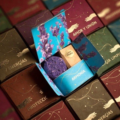 Caixas coloridas com texto em espanhol e produto aromático roxo em caixa aberta