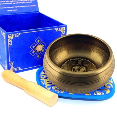 Tigela tibetana de metal com almofada azul, malhete de madeira e caixa azul com padrão dourado