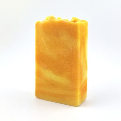 Sabonete em barra retangular laranja e amarelo marmoreado com textura irregular no topo