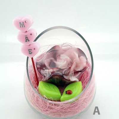 Rosa artificial cor-de-rosa em vidro inclinado com folhas verdes e corações cor-de-rosa com letras M Ã E