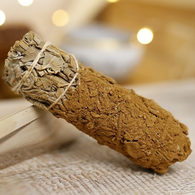 Vela de sálvia branca coberta de pó castanho sobre tecido bege