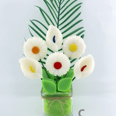 Arranjo de flores artificiais em vaso de vidro com flores brancas e folhas verdes