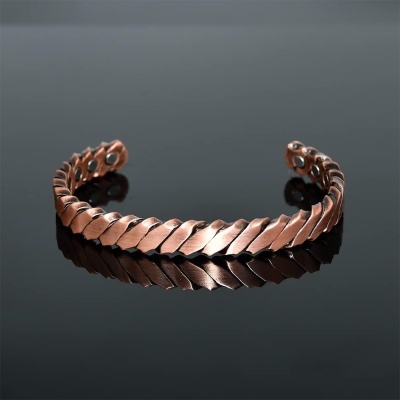 Pulseira aberta de metal cobre com design de folhas entrelaçadas e ímanes nas extremidades