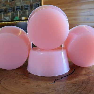 Sabonetes redondos cor-de-rosa sobre superfície de madeira rústica