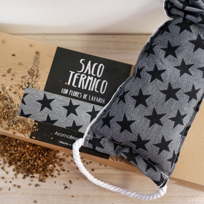 Saco térmico cinza com estrelas pretas e caixa de cartão com texto SACO TÉRMICO CON FLORES DE LAVANDA