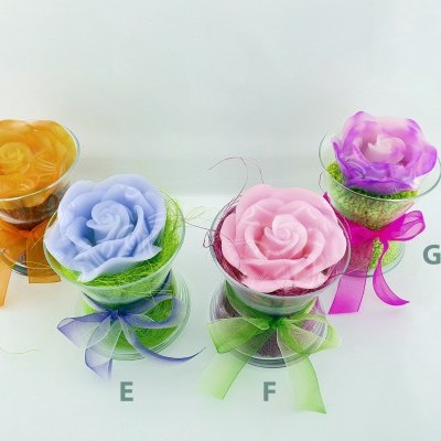 Velas em forma de rosa com copos transparentes e fitas coloridas
