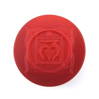 Objeto redondo vermelho com relevo de símbolo geométrico