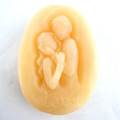Sabonete oval bege com relevo de casal abraçado e texto Love