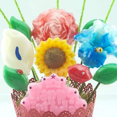 Arranjo decorativo de flores coloridas e placa rosa com 'Happy Birthday'