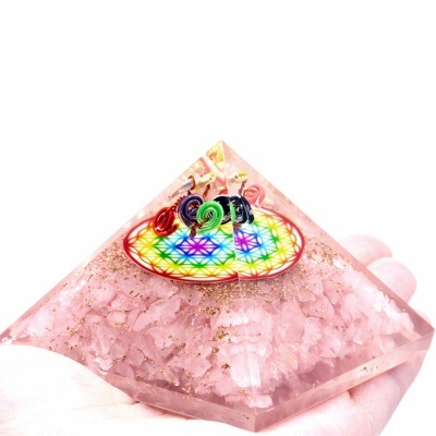 Pirâmide translúcida com cristais rosa e decoração colorida no topo
