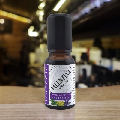 Frasco pequeno de vidro com rótulo VALENTINA BODY CARE e tampa preta sobre superfície de madeira.