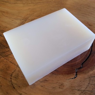 Barra de sabão branca translúcida em madeira rústica