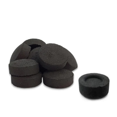 Discos pretos de carvão para narguilé sobre fundo branco.