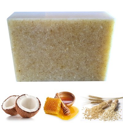 Barra de sabonete bege com textura granulada, coco partido, favos de mel e aveia com trigo