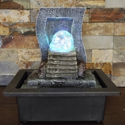 Fonte decorativa de água com esfera luminosa azul e base preta