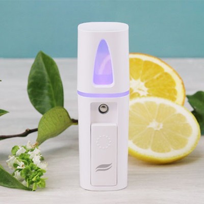 Dispositivo branco com luz violeta, limões cortados e folhas verdes ao fundo