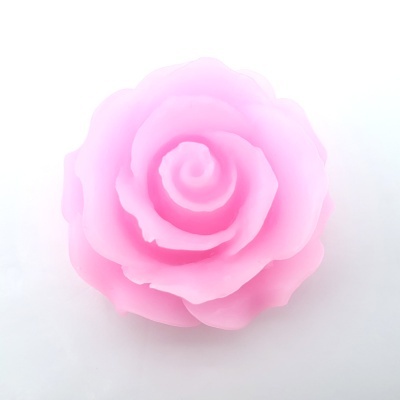 Vela em forma de rosa cor-de-rosa sobre fundo branco