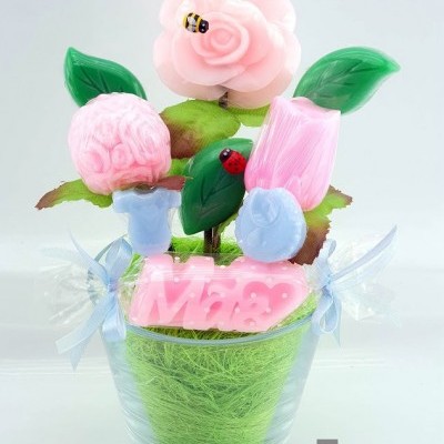 Arranjo decorativo de velas em forma de flores com suporte transparente e fita azul