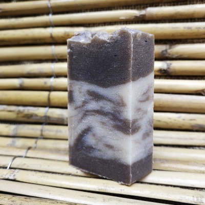 Sabonete artesanal marbled castanho e branco sobre fundo de bambu