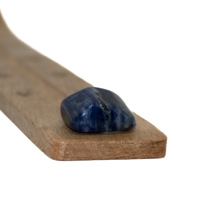 Pedra polida azul sobre tábua de madeira clara