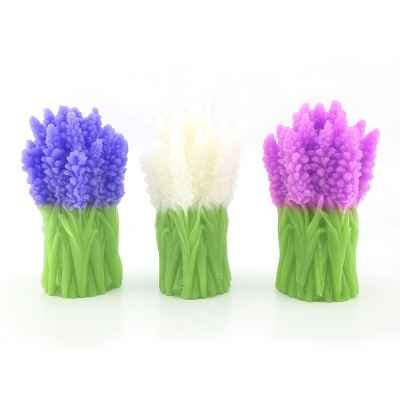 Três velas em forma de ramo de flores com flores azul, branca e rosa