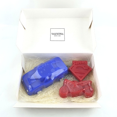 Sabonetes em formato de carro azul, moto vermelha e símbolo Superman vermelho numa caixa branca