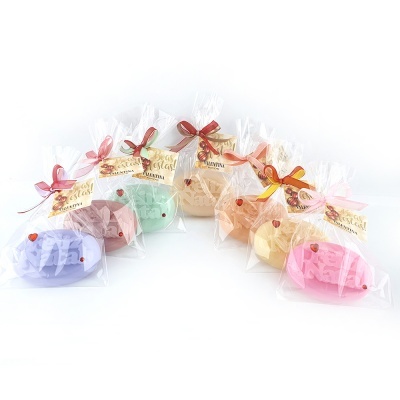 Sabonetes coloridos embalados com laços e etiquetas em fundo branco