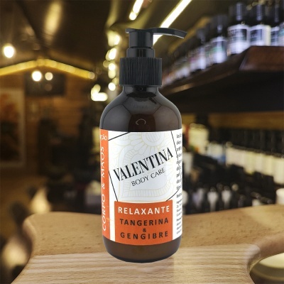 Frasco de loção corporal Valentina Body Care com rótulo branco e laranja numa bancada de madeira