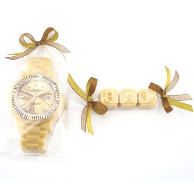 Relógio dourado de pulso embalado com cubos de letras amarelos em fundo branco