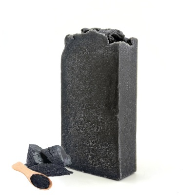 Sabonete sólido preto com colher de pó preto e pedaços pretos