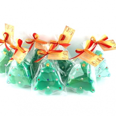 Velas verdes em forma de árvore de Natal decoradas e embaladas com fitas vermelhas