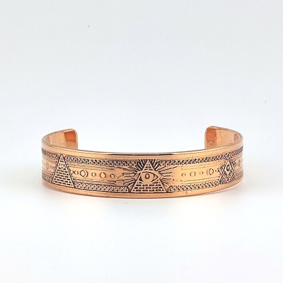 Pulseira de metal cobre com padrões gravados de pirâmides e olhos