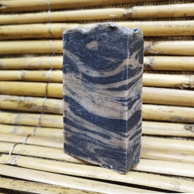 Sabonete artesanal marmoreado preto e bege em ripas de bambu