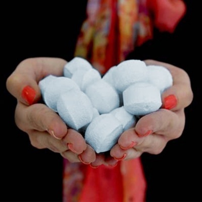 Mãos segurando pastilhas brancas com comprimento destacado