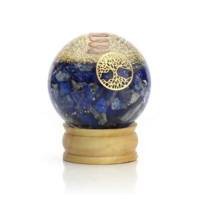 Esfera decorativa com pedra azul e emblema dourado numa base de madeira clara