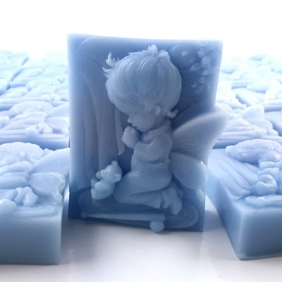 Sabonete azul com anjo em relevo e padrões florais em fundo branco