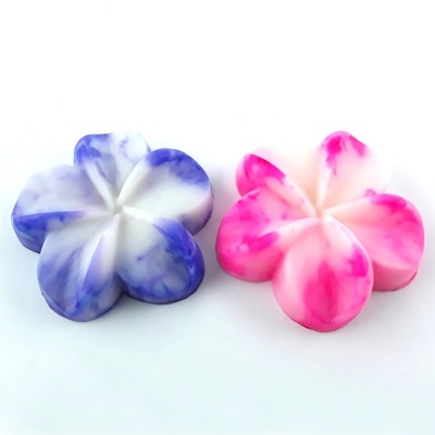 Dois sabonetes em forma de flor com padrão marmoreado azul e rosa